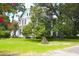 Charming two-story white home with black shutters and mature trees in a landscaped yard at 219 Rigby St, Reevesville, SC 29471
