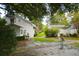 View of the backyard featuring brick walkways, mature landscaping, and charming white outbuildings at 219 Rigby St, Reevesville, SC 29471
