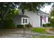 Exterior view of a charming white cottage with a shed, an American flag, and a stairway at 219 Rigby St, Reevesville, SC 29471