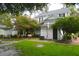 Backyard featuring a lush green lawn, brick walkways, and blooming trees around the classic white house at 219 Rigby St, Reevesville, SC 29471