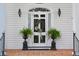Inviting front entrance featuring a decorative door, sconces, and potted ferns at 219 Rigby St, Reevesville, SC 29471