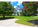 A meticulously kept front yard with a circular driveway leading to a classic white home surrounded by flowering trees at 219 Rigby St, Reevesville, SC 29471