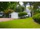 Backyard featuring a detached garage with a pergola, adjacent to a lush green lawn at 219 Rigby St, Reevesville, SC 29471