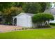 Backyard featuring a detached garage with a pergola next to a lush green lawn at 219 Rigby St, Reevesville, SC 29471