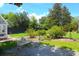 Landscaped backyard featuring a greenhouse and a beautiful garden bench at 219 Rigby St, Reevesville, SC 29471