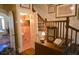 Hallway with wooden staircase and half-bathroom with pink floral wallpaper at 219 Rigby St, Reevesville, SC 29471