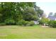 Expansive lawn featuring lush trees and meticulous landscaping at 219 Rigby St, Reevesville, SC 29471