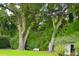 Picturesque backyard with mature trees and a white bench at 219 Rigby St, Reevesville, SC 29471