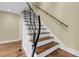 An elegant staircase with wood treads, white risers, and a wrought iron railing at 2224 Shoreline Dr, Johns Island, SC 29455