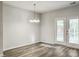 Dining room with wood flooring and a modern chandelier adjacent to double patio doors at 232 Buchanan Cir, Goose Creek, SC 29445