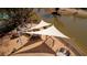 Aerial view of a playground with play structures, swings, and sunshades next to the community lake at 2461 Lieutenant Dozier Dr, Johns Island, SC 29455