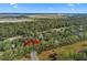 A forested neighborhood is seen from above near a golf course and marsh under a blue sky at 2515 Cat Tail Pond Rd, Seabrook Island, SC 29455