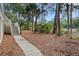 Backyard area featuring a stone path, lush foliage and stairs leading to the house at 2515 Cat Tail Pond Rd, Seabrook Island, SC 29455