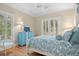 Inviting bedroom with a floral bedspread, hardwood floors, white trim, and plenty of natural light from shuttered windows at 2515 Cat Tail Pond Rd, Seabrook Island, SC 29455