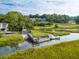 Scenic view of a dock and waterway with lush marsh grasses and mature trees at 2515 Cat Tail Pond Rd, Seabrook Island, SC 29455