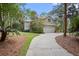 Beautifully landscaped home exterior with a winding driveway and lush greenery at 2515 Cat Tail Pond Rd, Seabrook Island, SC 29455