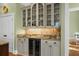 An elegant bar area in the kitchen features a wine cooler, granite countertops, and plenty of storage at 2515 Cat Tail Pond Rd, Seabrook Island, SC 29455
