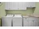 Well-organized laundry room with white cabinets, a sink, and modern washer and dryer units for convenient chores at 2515 Cat Tail Pond Rd, Seabrook Island, SC 29455