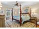 A serene bedroom features a four-poster bed, soft lighting, and views of the lush greenery outside at 2515 Cat Tail Pond Rd, Seabrook Island, SC 29455