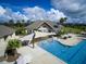 Stunning aerial view of a community pool with a splashpad, shaded seating, and palm trees under a bright blue sky at 2515 Cat Tail Pond Rd, Seabrook Island, SC 29455