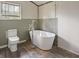 A bathroom featuring a modern standalone tub and toilet set against gray lower walls at 2604 Highway 78, Dorchester, SC 29437