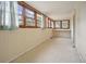 Image shows sunroom with several windows letting in natural light and vintage vinyl flooring at 2604 Highway 78, Dorchester, SC 29437