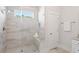 Modern bathroom with glass shower, white cabinets, neutral tile, and a window for natural light at 2901 Eddy Dr, Mount Pleasant, SC 29466
