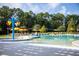 Community pool with colorful umbrellas, a water feature, and lounge chairs surrounded by green trees at 295 Citrus Dr, Summerville, SC 29486