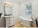 Bright bathroom featuring a freestanding tub, elegant vanity, and modern lighting fixtures at 3 Cross Ln, Isle of Palms, SC 29451