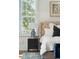 Cozy bedroom showcasing a tufted headboard, stylish nightstand, and natural light from the window at 3 Cross Ln, Isle of Palms, SC 29451