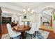 Elegant dining room featuring wood floors, a blue rug, and stylish white dining chairs at 3 Cross Ln, Isle of Palms, SC 29451