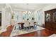 Bright dining room with wood floors, six chairs, and natural light from the large windows at 3 Cross Ln, Isle of Palms, SC 29451