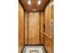 Residential elevator features paneled walls, a tiled floor, a handrail, and a phone at 3 Cross Ln, Isle of Palms, SC 29451