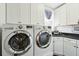 Well-equipped laundry room featuring modern washer, dryer, and ample cabinet storage at 3 Cross Ln, Isle of Palms, SC 29451
