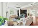 Open living room featuring hardwood floors, neutral sofas, stylish decor and an adjacent bar area at 3 Cross Ln, Isle of Palms, SC 29451