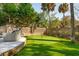 A putting green is flanked by a brick wall and tropical palms, enhancing the appeal of this backyard at 3 Cross Ln, Isle of Palms, SC 29451