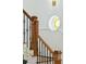 Elegant staircase showcasing wooden banister with iron spindles and a decorative round window at 3 Cross Ln, Isle of Palms, SC 29451