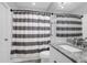 Well-lit bathroom features striped shower curtain, commode, granite countertop and modern sink at 300 Bucksley Ln # 104, Charleston, SC 29492