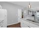 Galley kitchen showcases white cabinetry, stainless sink, and stylish fixtures and opens to living area at 300 Bucksley Ln # 104, Charleston, SC 29492