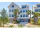 Stunning exterior of a multi-story coastal home featuring a gray garage and complemented by lush palm trees at 3034 Bell Cv Aly, Johns Island, SC 29455