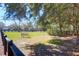 Scenic fenced pasture with a tranquil bench offering views of the tree lined neighborhood at 3034 Bell Cv Aly, Johns Island, SC 29455