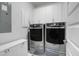 Modern laundry room features gray washer and dryer, white cabinets and an ironing board at 3034 Bell Cv Aly, Johns Island, SC 29455