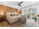 Bright main bedroom with private balcony access, ceiling fan, and natural-tone accent wall at 3034 Bell Cv Aly, Johns Island, SC 29455