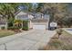 Home exterior showing the garage, driveway, landscaping, and partial view of the backyard and surrounding trees at 309 Edinburgh St, Summerville, SC 29483