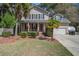 Charming two-story home with landscaped front yard, covered porch, red door, and attached garage at 309 Edinburgh St, Summerville, SC 29483