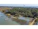 Breathtaking aerial view of waterfront property with a private dock, lush greenery, and stunning water views at 410 E Indian Ave, Folly Beach, SC 29439