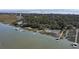 Aerial view of a community with a mix of waterfront homes and lush trees with water access at 410 E Indian Ave, Folly Beach, SC 29439