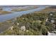 Aerial view of waterfront community with homes surrounded by mature trees and water access at 410 E Indian Ave, Folly Beach, SC 29439