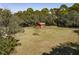 Private backyard with a vintage shed nestled among lush green grass and mature trees offering a secluded setting at 410 E Indian Ave, Folly Beach, SC 29439