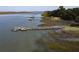 Scenic view of a weathered private dock along the marshy waterfront with boat and lush trees at 410 E Indian Ave, Folly Beach, SC 29439